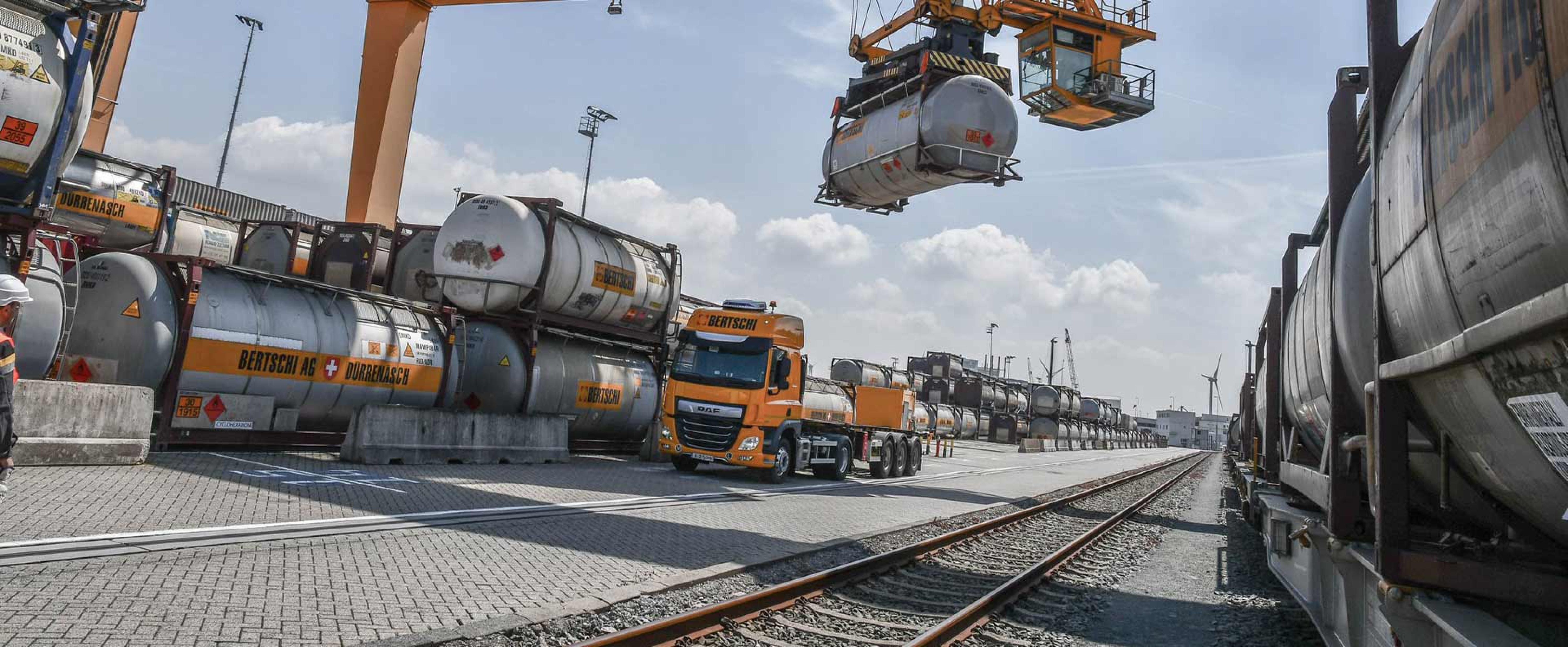 A BERTSCHI truck unloads his liquid container using a heavy lift crane.