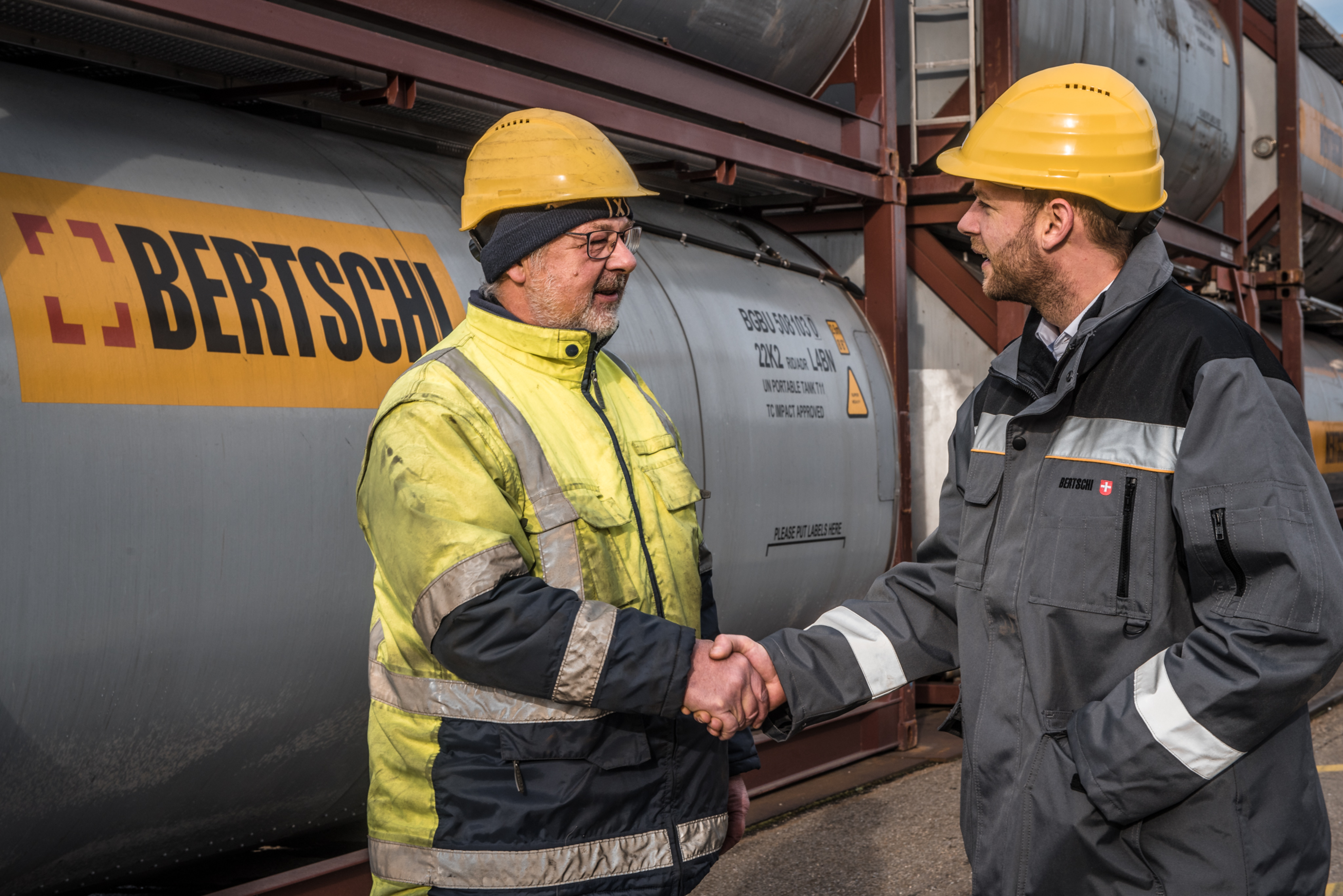 two men shaking hands wearing Bertschi uniforms