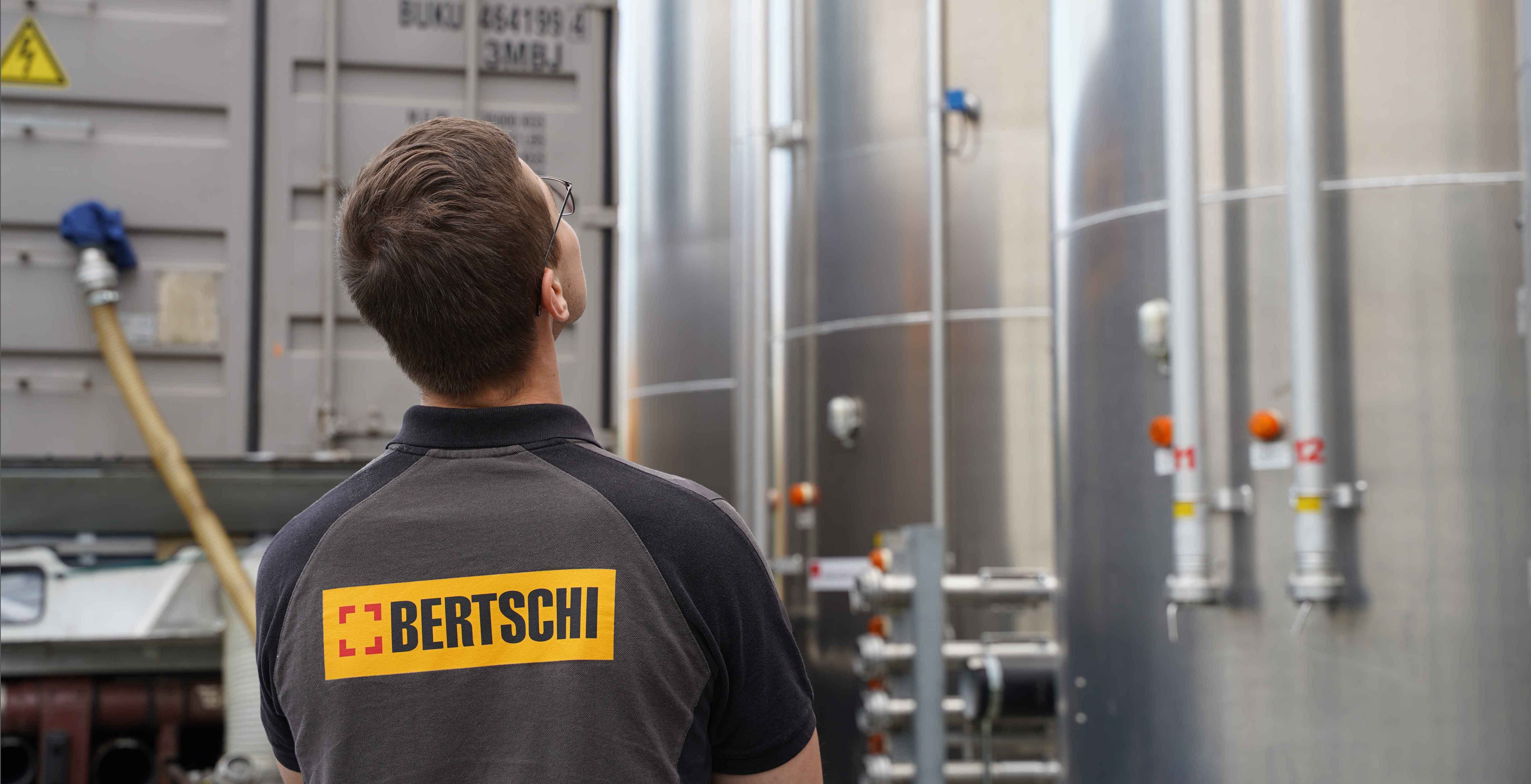 Bertschi driver looking up at large silos