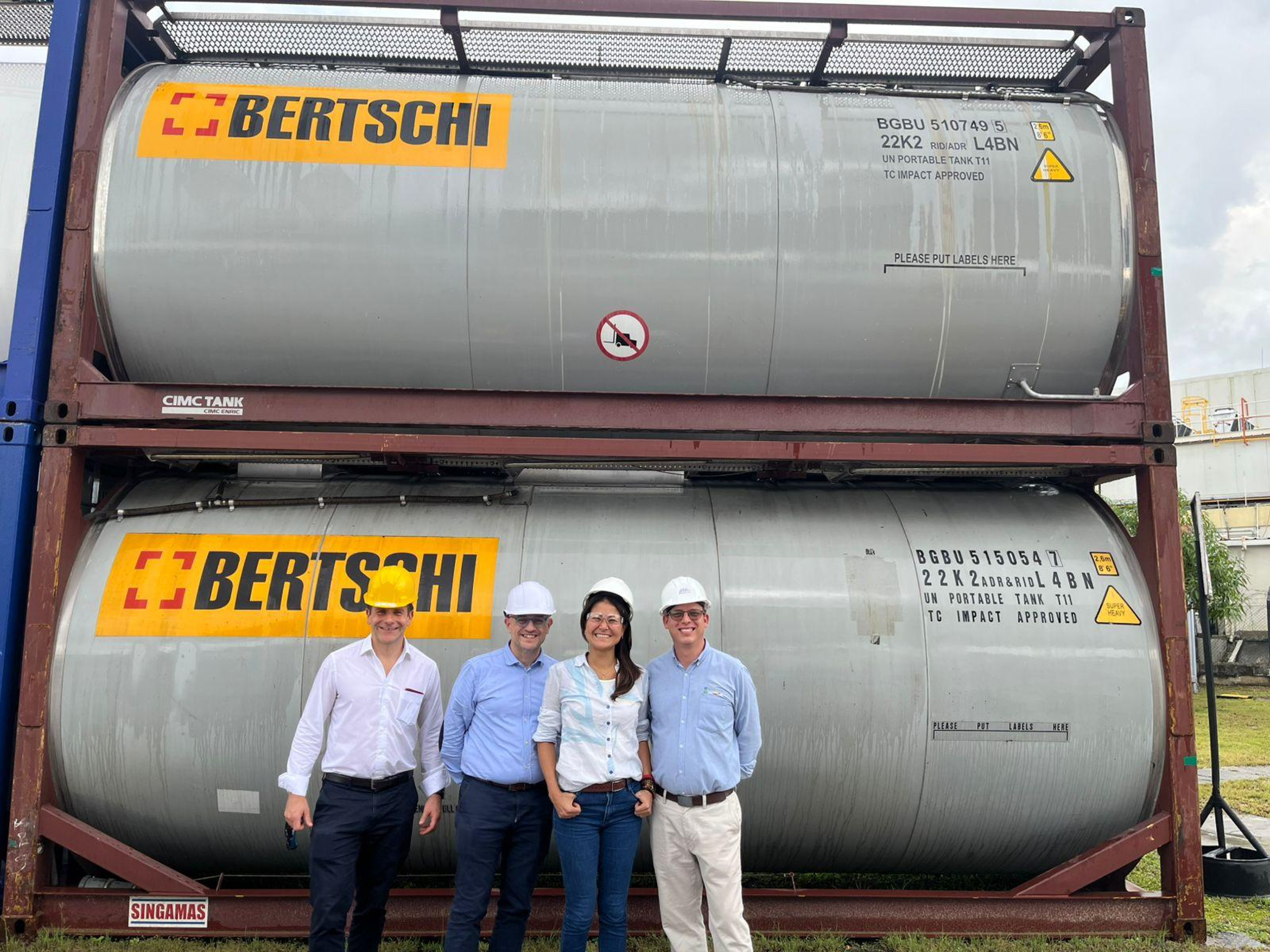 4 Bertschi team members posing in front of tank containers