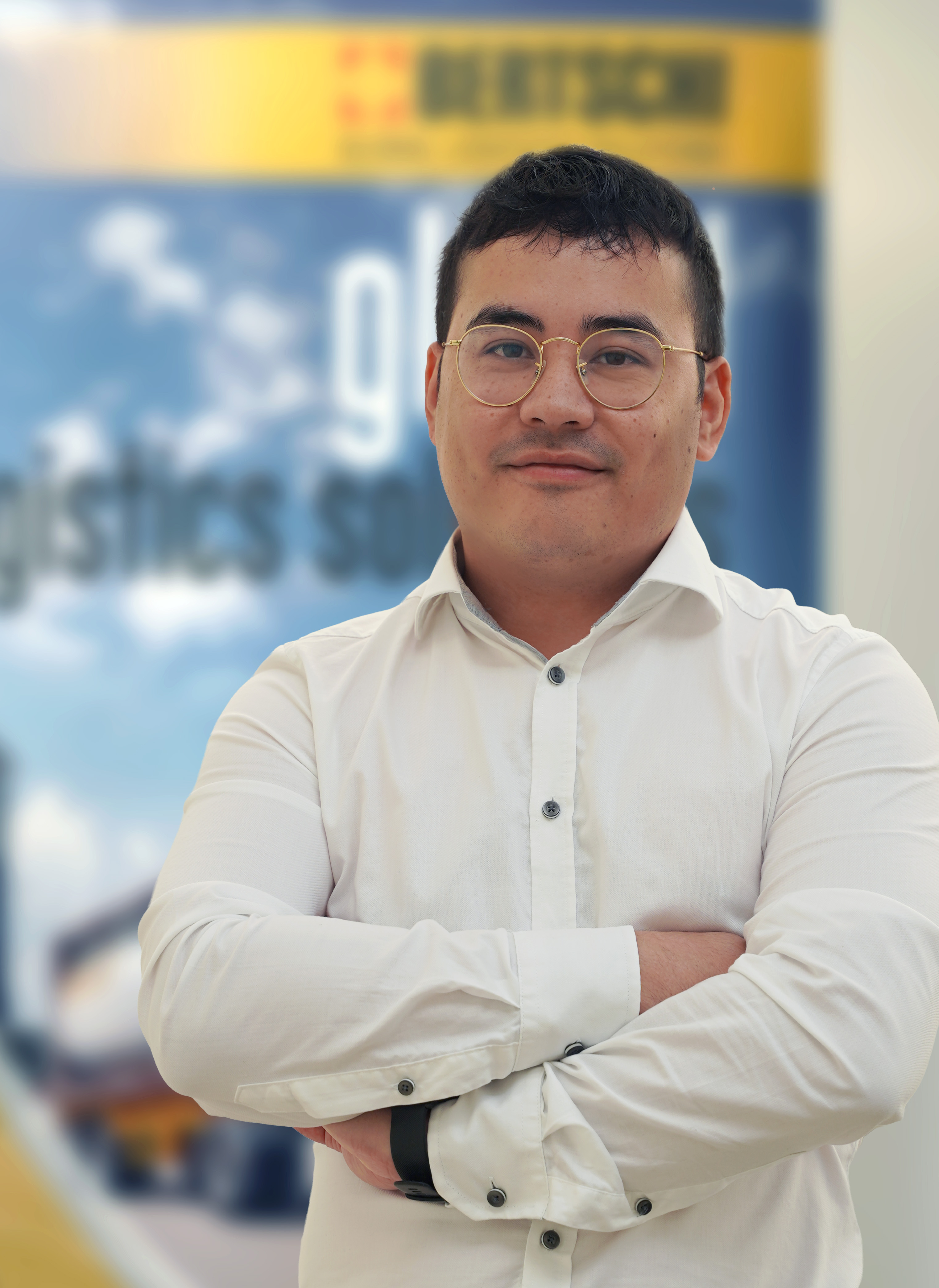 Picture of Tobias Kaufmann, Bertschi head of SHEQ, in white button down standing cross-armed in front of the Bertschi banner