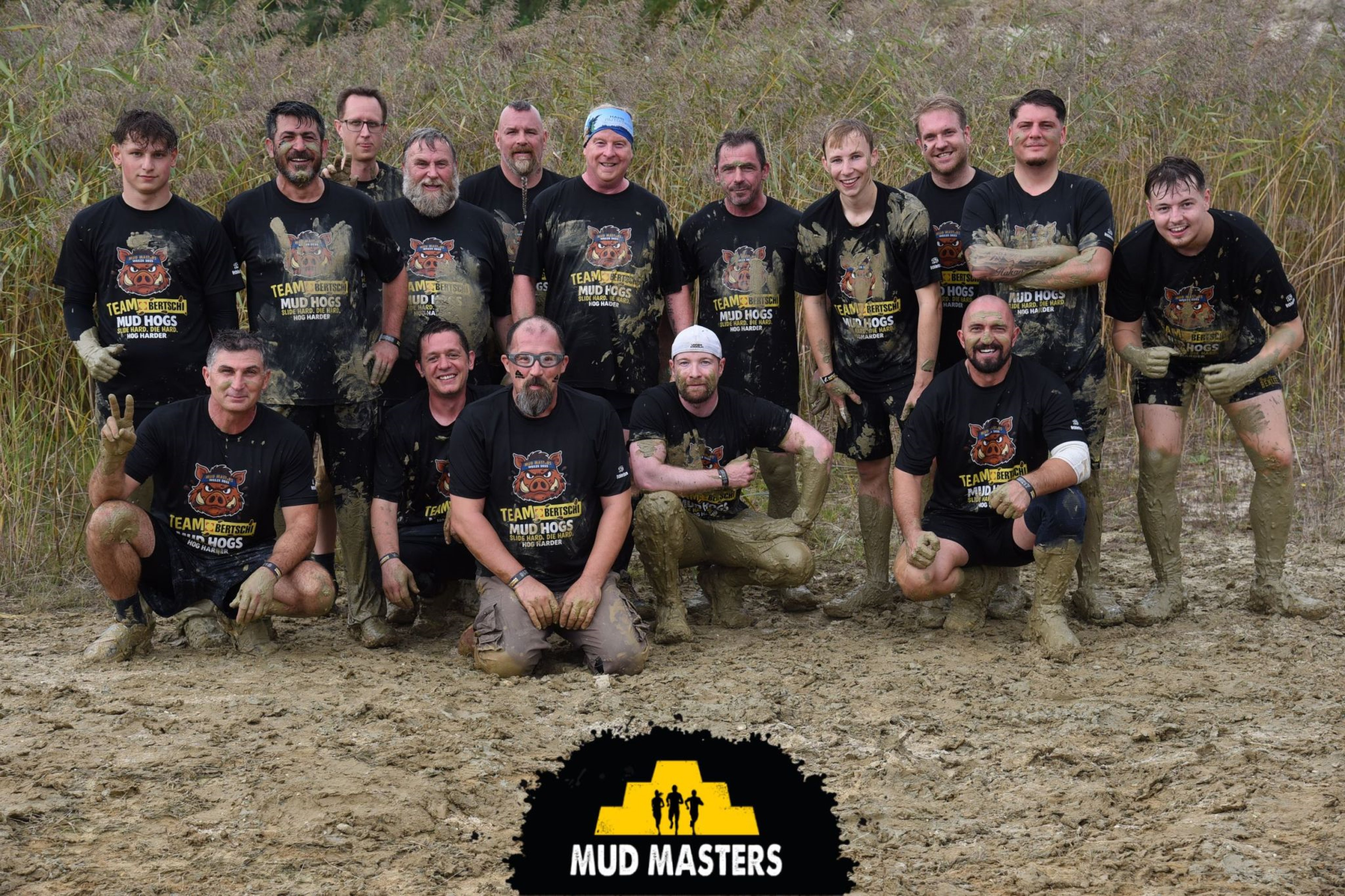 Employees from Köln in a group photo full of mud 