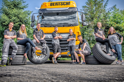 Apprentices posing infront of a Bertchi trucks with tires