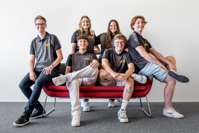 Apprentices posed around a sofa