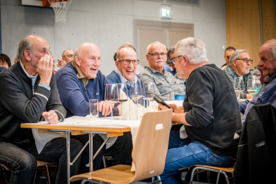 People are sitting around a table, laughing together