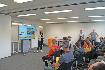 woman presenting about the company in front of children and their parents
