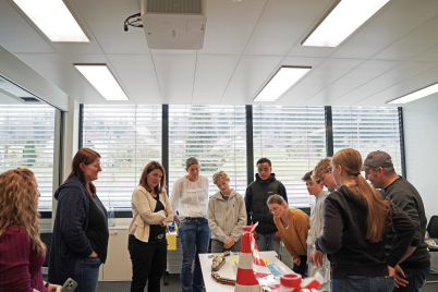 people are standing around a table and talking