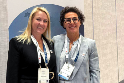 Two attendees pose together in front of the EPCA Annual Meeting backdrop.
