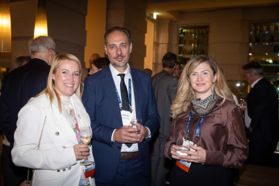 Three colleagues meet during an evening networking reception in Vienna.