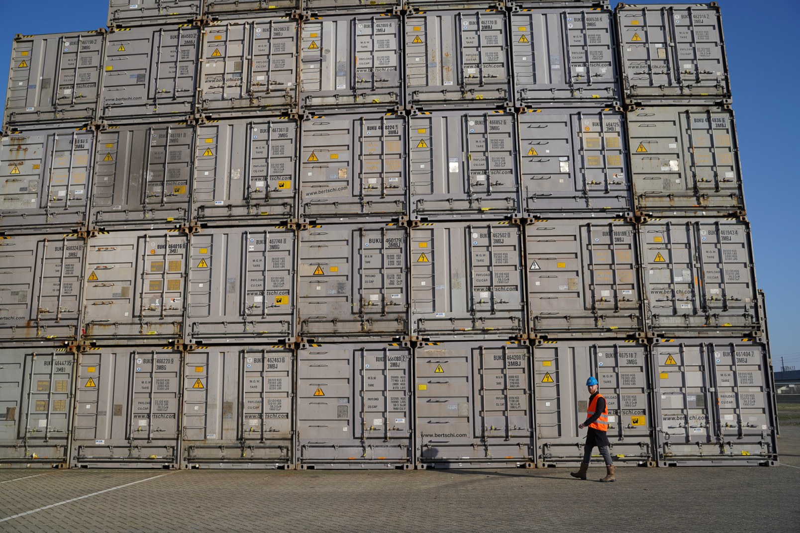 employee walking in front of a wall of box Bertschi containers