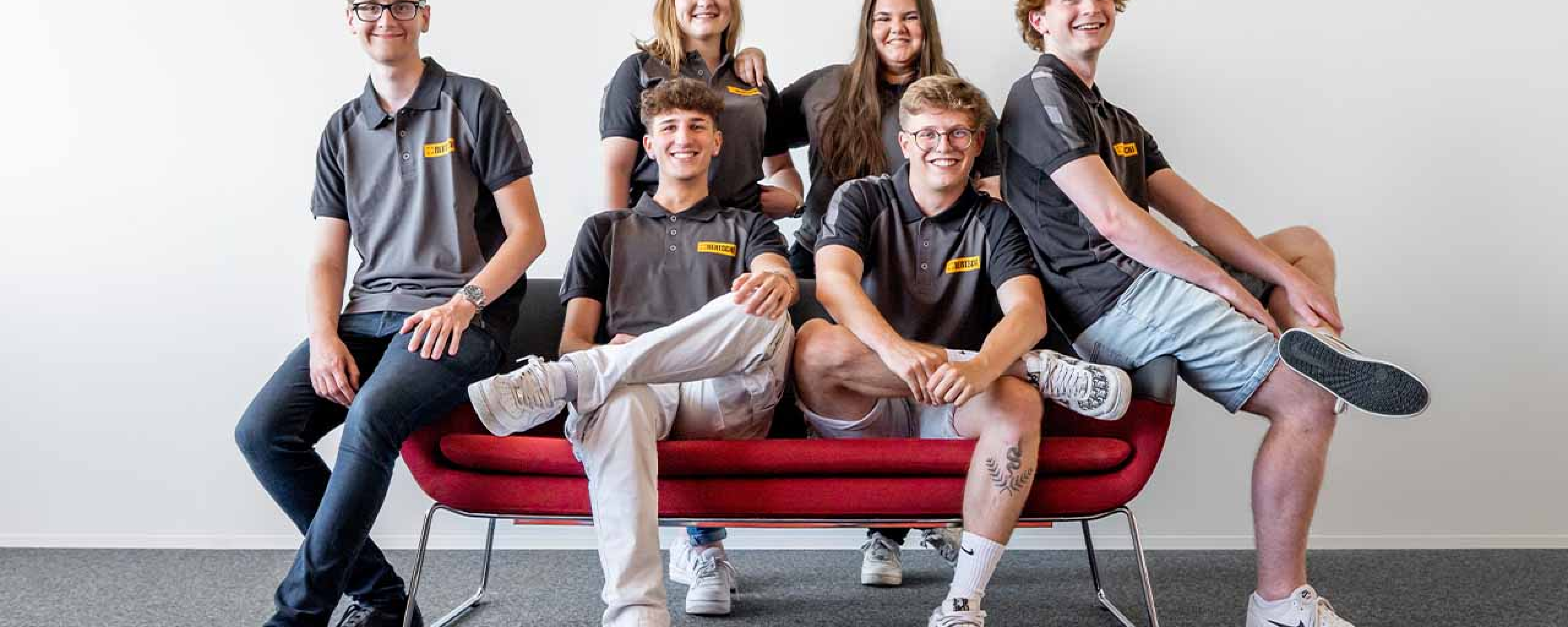 Bertschi Apprentices sitting on a red couch