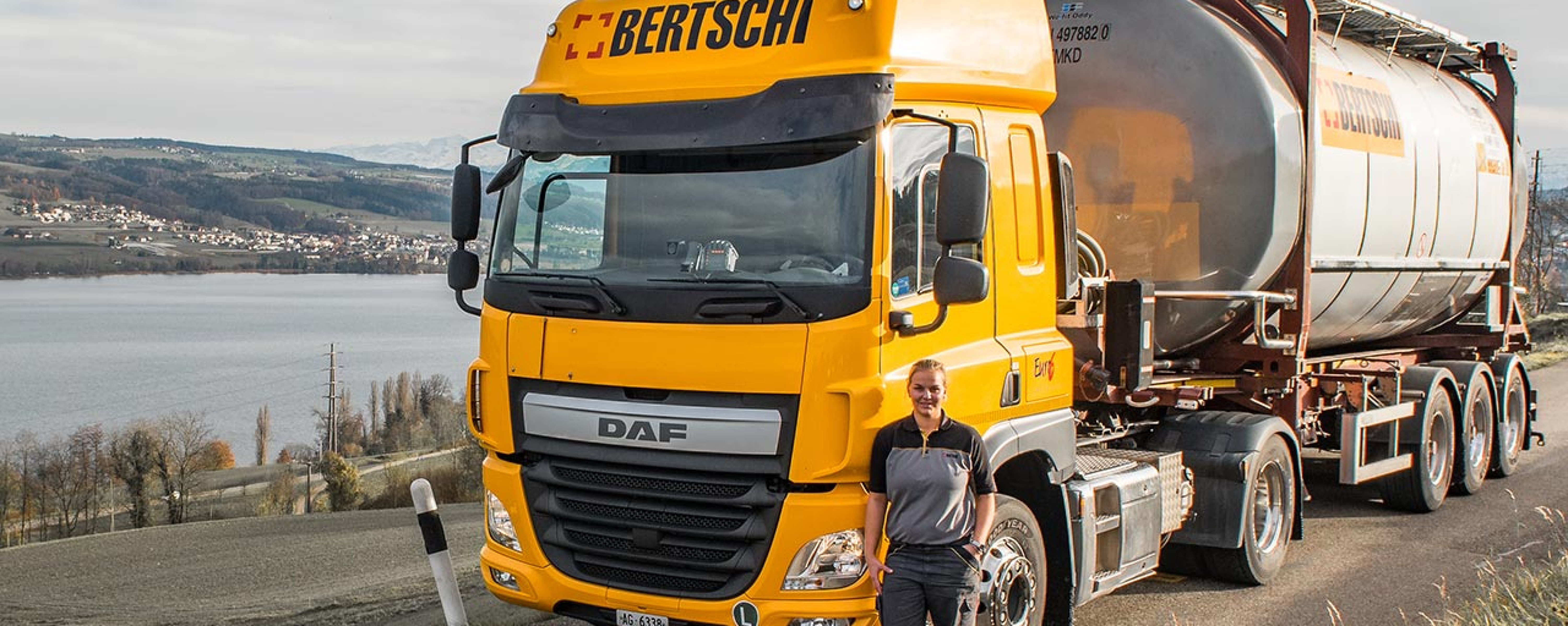 Bertschi truck parked next to the lake with Driver Fiona standing next to it