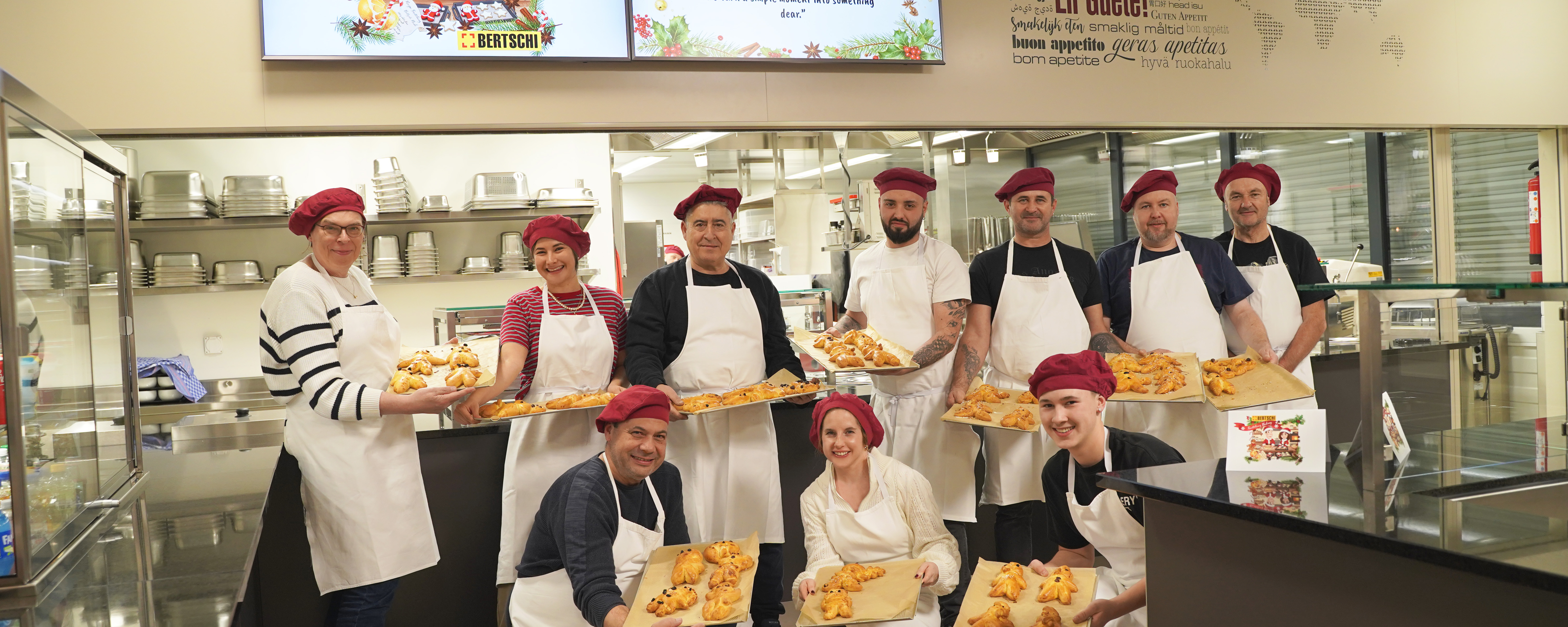 people standing in the kitchen holding their Grittibänz