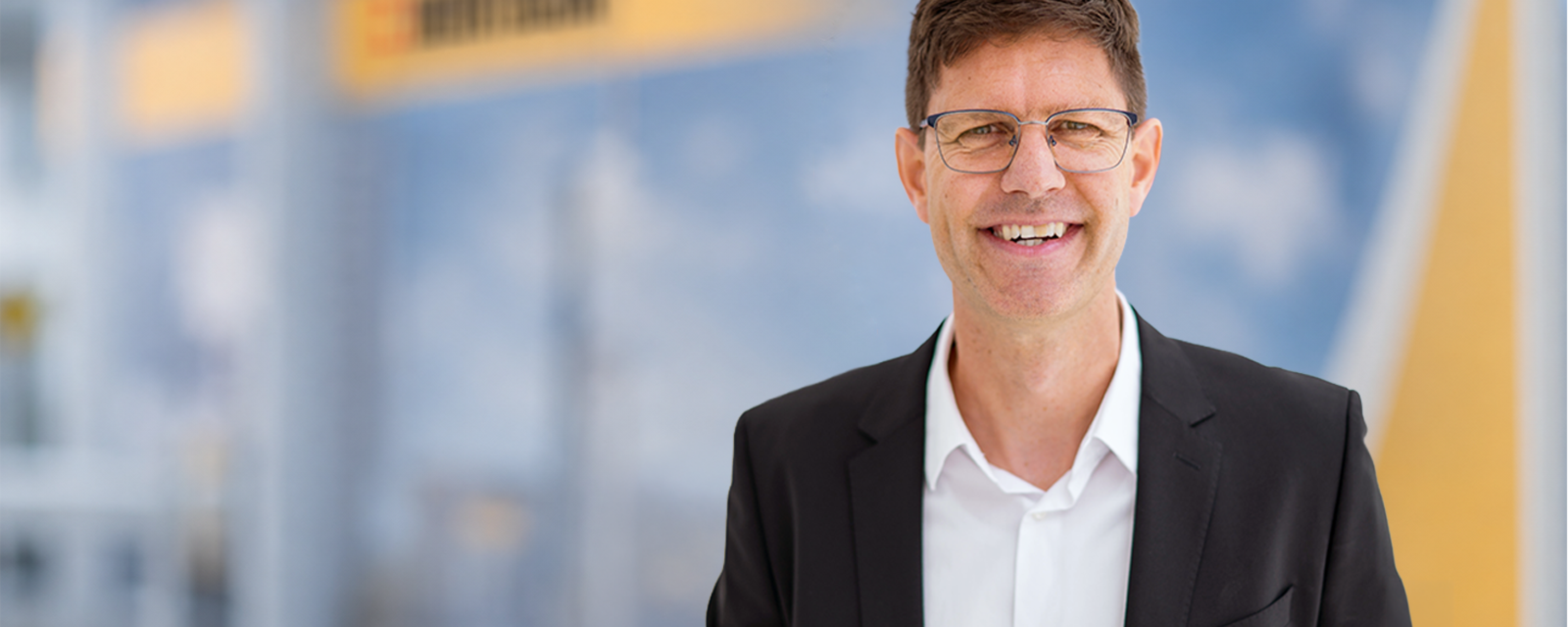 Alain Remund portrait standing in front of Bertschi background